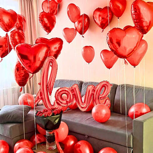 Living room decorated with red heart-shaped balloons and a 'LOVE' balloon.