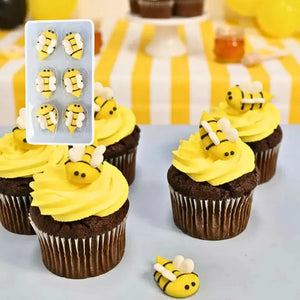 Bee-themed royal icing cake decorations on cupcakes