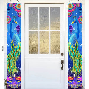 Decorative peacock happy diwali couplets hanging on a white door with a glass panel.