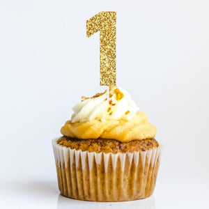 Gold glitter number 1 cake topper inserted on cupcake