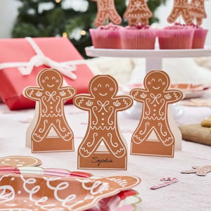 gingerbread man place cards arranged beside festive holiday plates and napkins