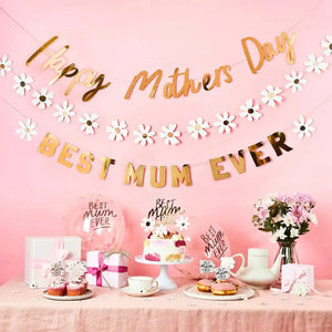 Decorative setup for Mother's Day with 'Happy Mother's Day' and 'Best Mum Ever' banners, cake, tea set, and flowers