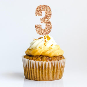 Rose gold glitter number 3 birthday cake topper inserted on cupcake