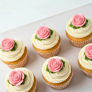 Pink edible rose cake decorations with green leaves
