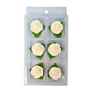 White edible rose cake decorations with green leaves
