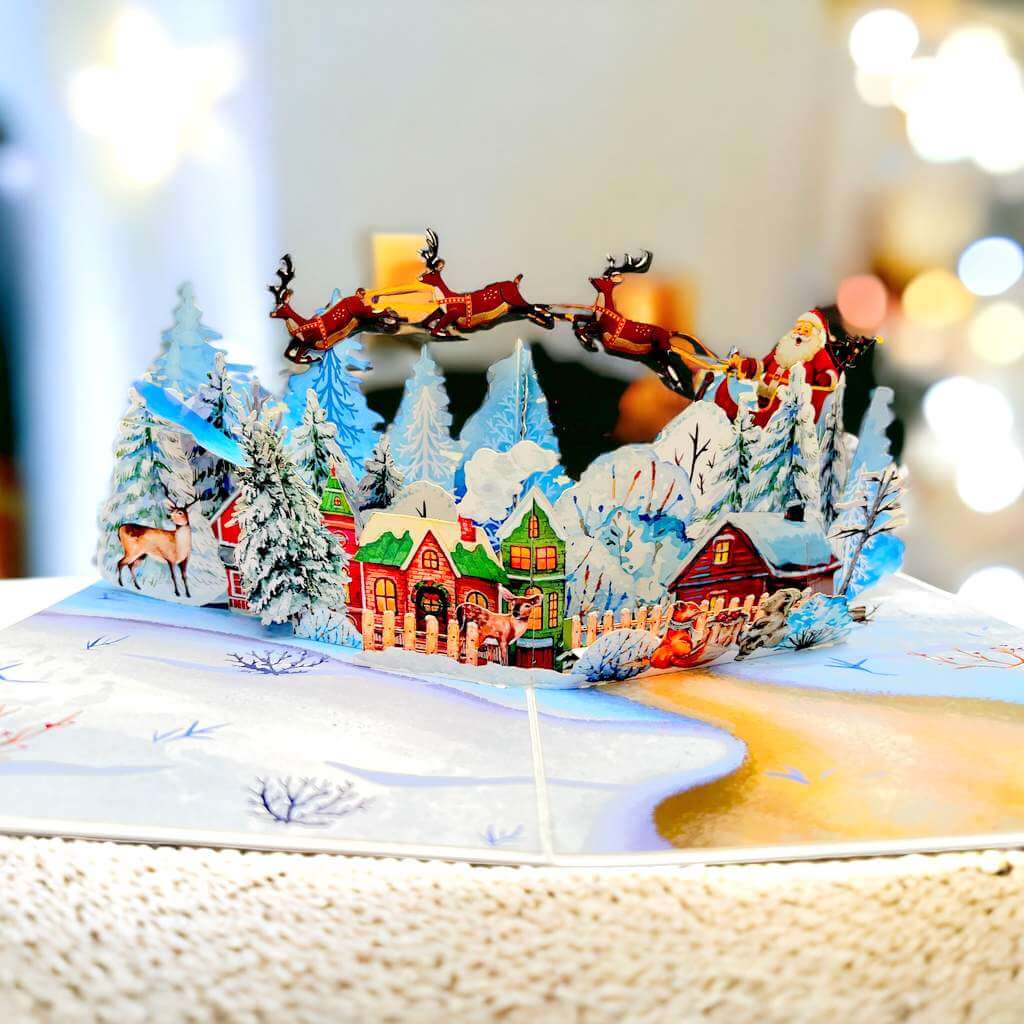 Snowy Village with Flying Santa on Sleigh & Reindeers Pop Card