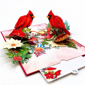 Red cardinal birds surrounded by poinsettias on a Christmas card