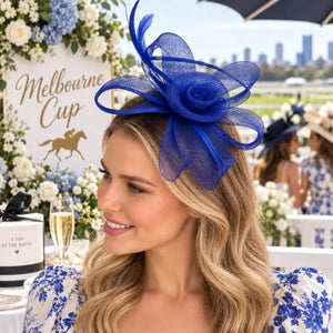 Vibrant blue race-day fascinator with sculptural mesh loops and feathers