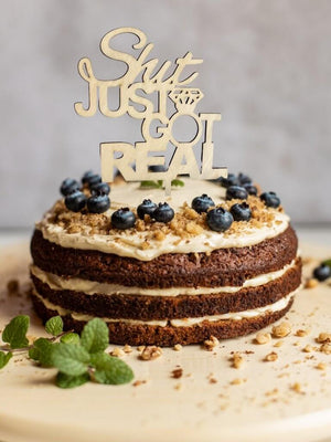 Wooden 'Shit Jut Got Real' Engagement Cake Topper