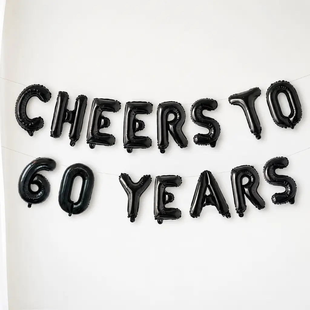 Black balloon letters spelling 'Cheers to 60 Years' on a white background