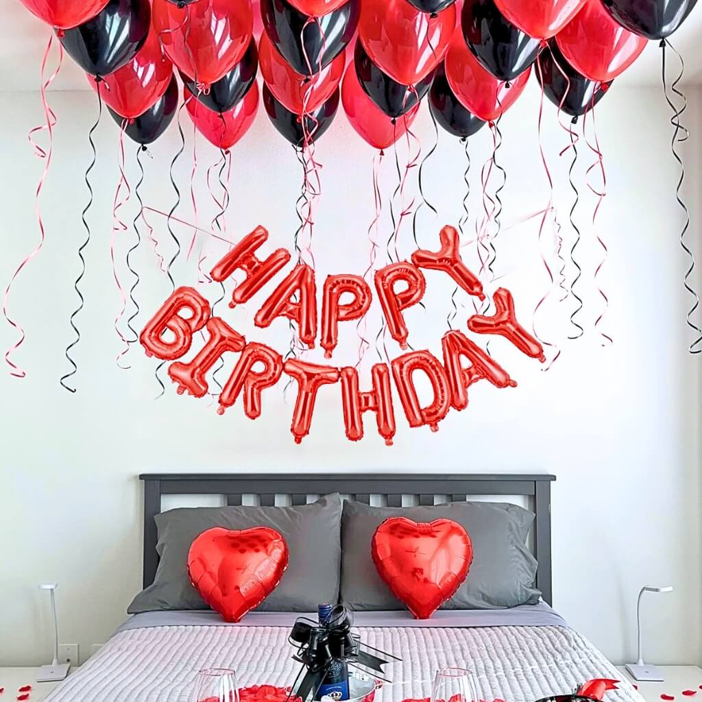 Bedroom with red and black balloons spelling 'Happy Birthday' above a bed.