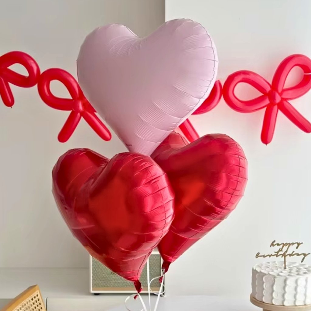 Heart-shaped balloons with 'Happy Birthday' text in the background