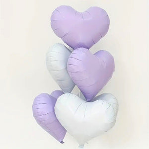 Heart-shaped balloons in pastel colors on a white background
