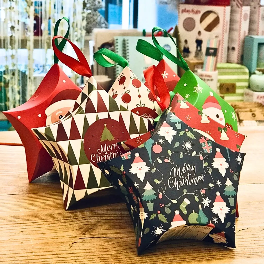 Set of colourful Christmas-themed star-shaped boxes with Santa Claus and snowman designs