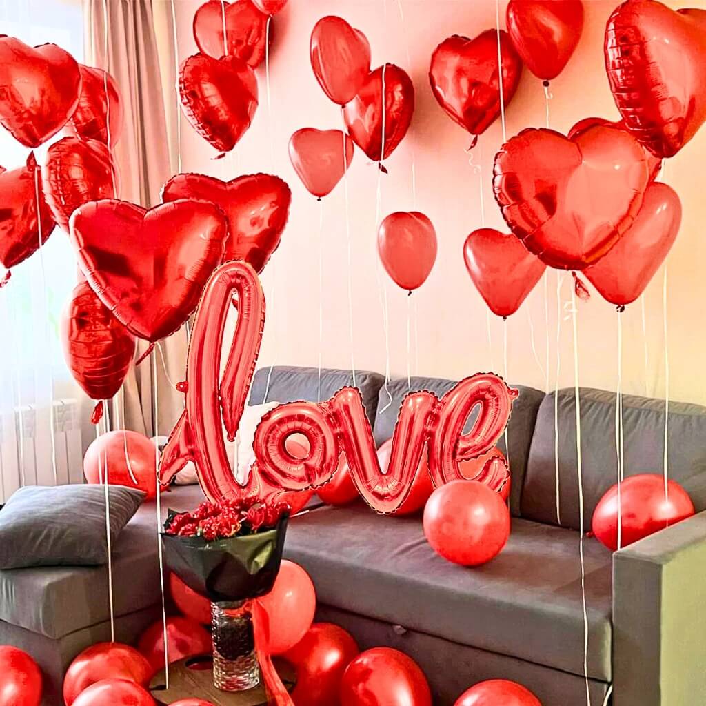 Living room decorated with red heart-shaped balloons and a 'LOVE' balloon.