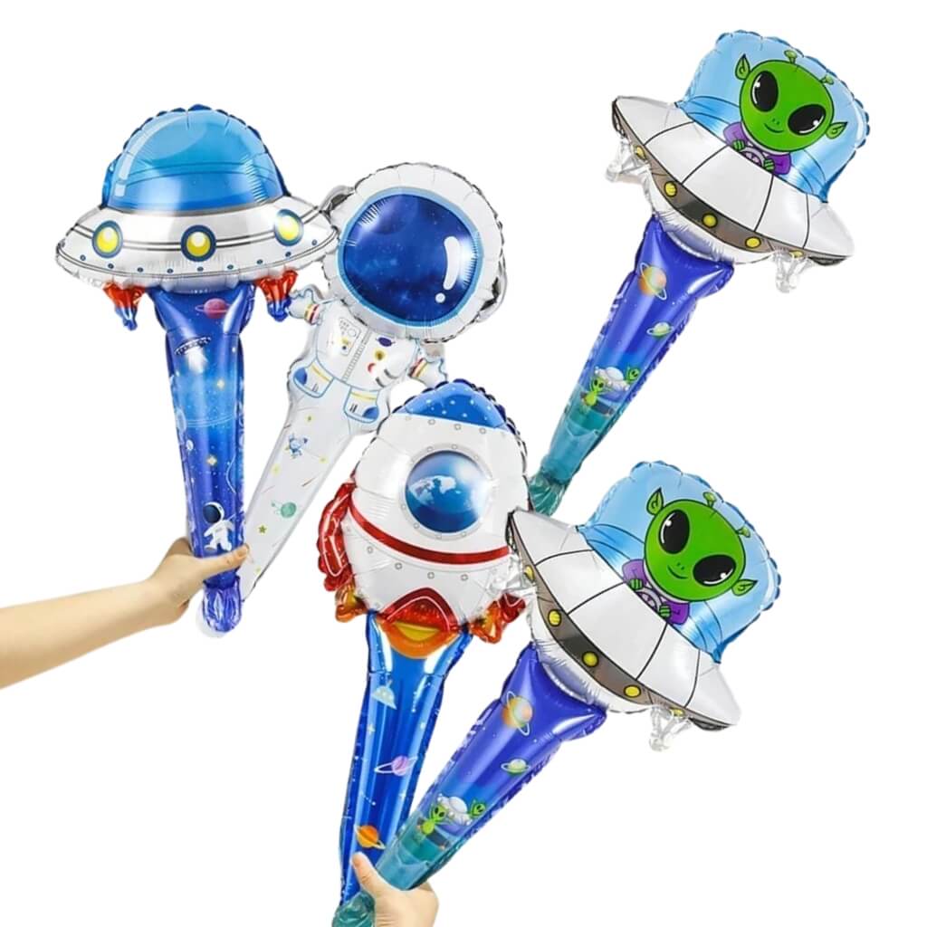 Space-themed balloons including UFOs, planets, and aliens held by a person against a light background.