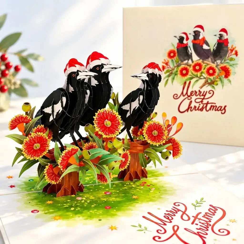 Three festive Australian magpies wearing Santa hats on a pop-up card