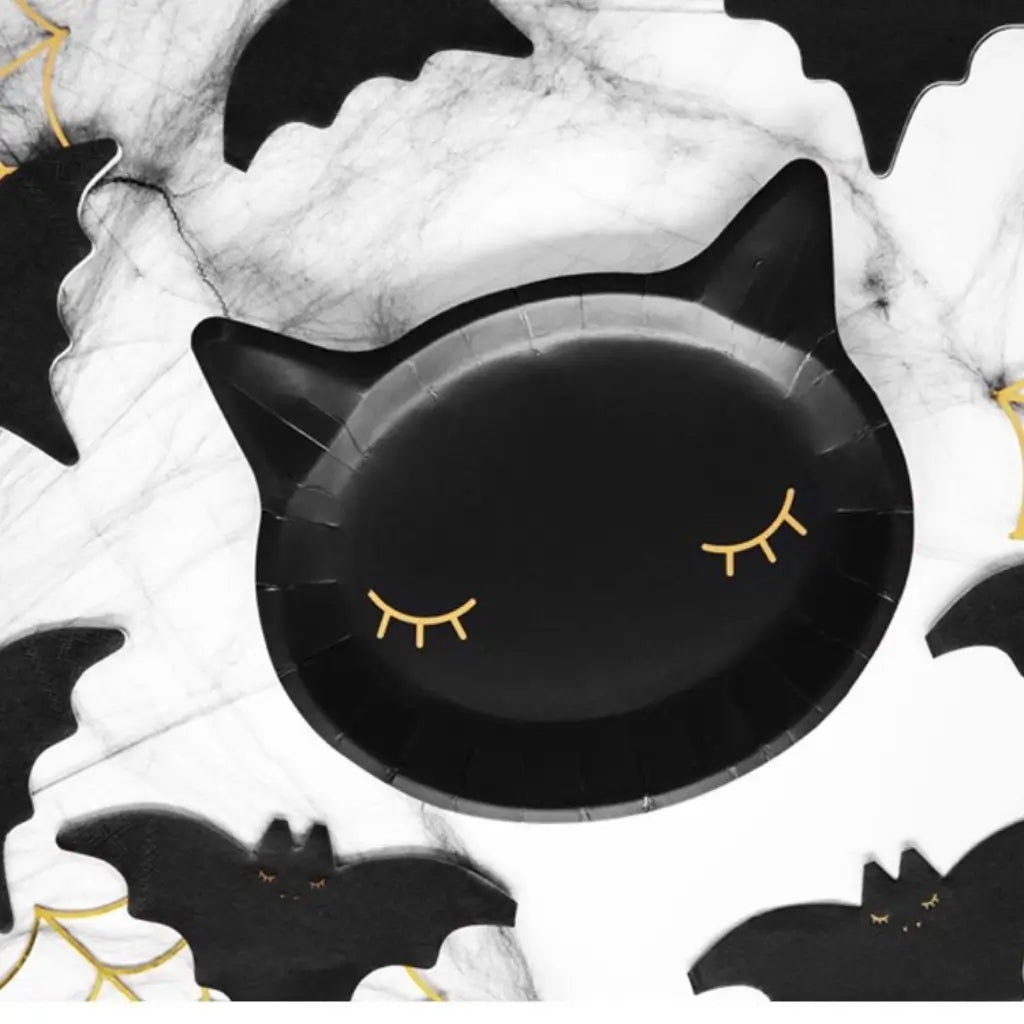 Black and gold cat-shaped plates for a witch-themed party
