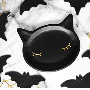 Black and gold cat-shaped plates for a witch-themed party