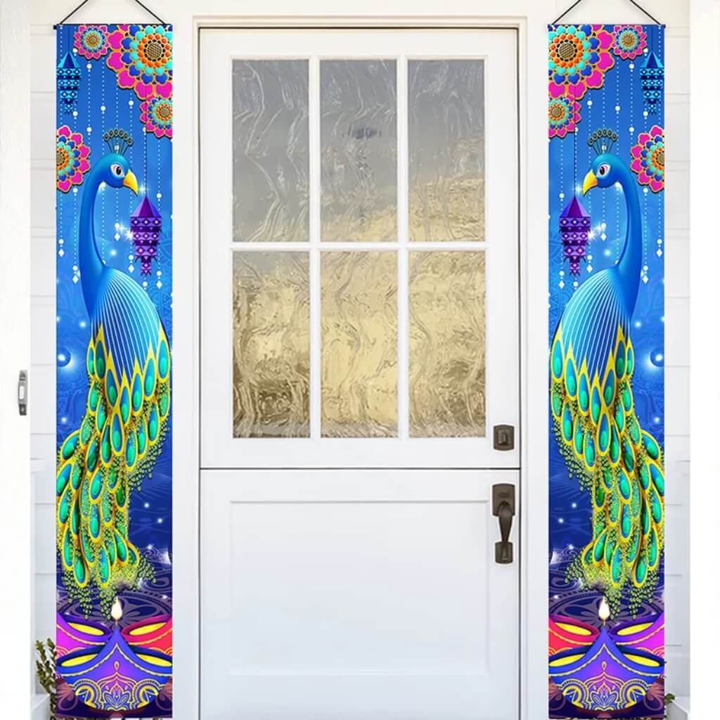 Decorative peacock happy diwali couplets hanging on a white door with a glass panel.