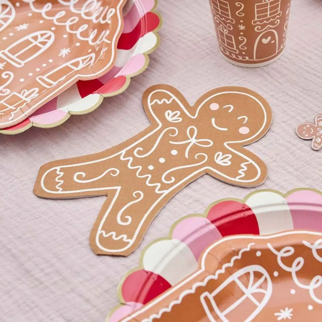 Gingerbread man paper napkins displayed on a Christmas dessert table setting