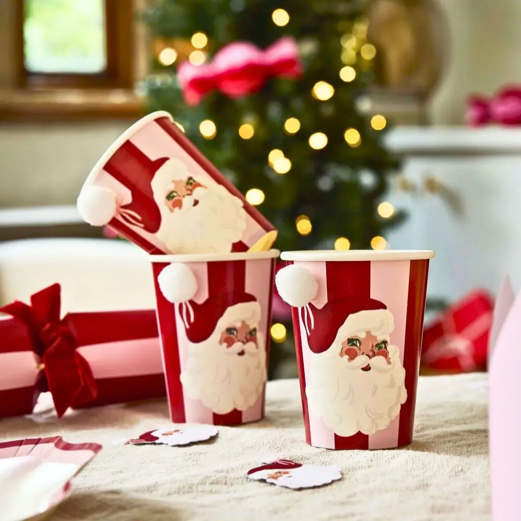 Hootyballoo Santa Baby paper cups displayed on a Christmas table setting