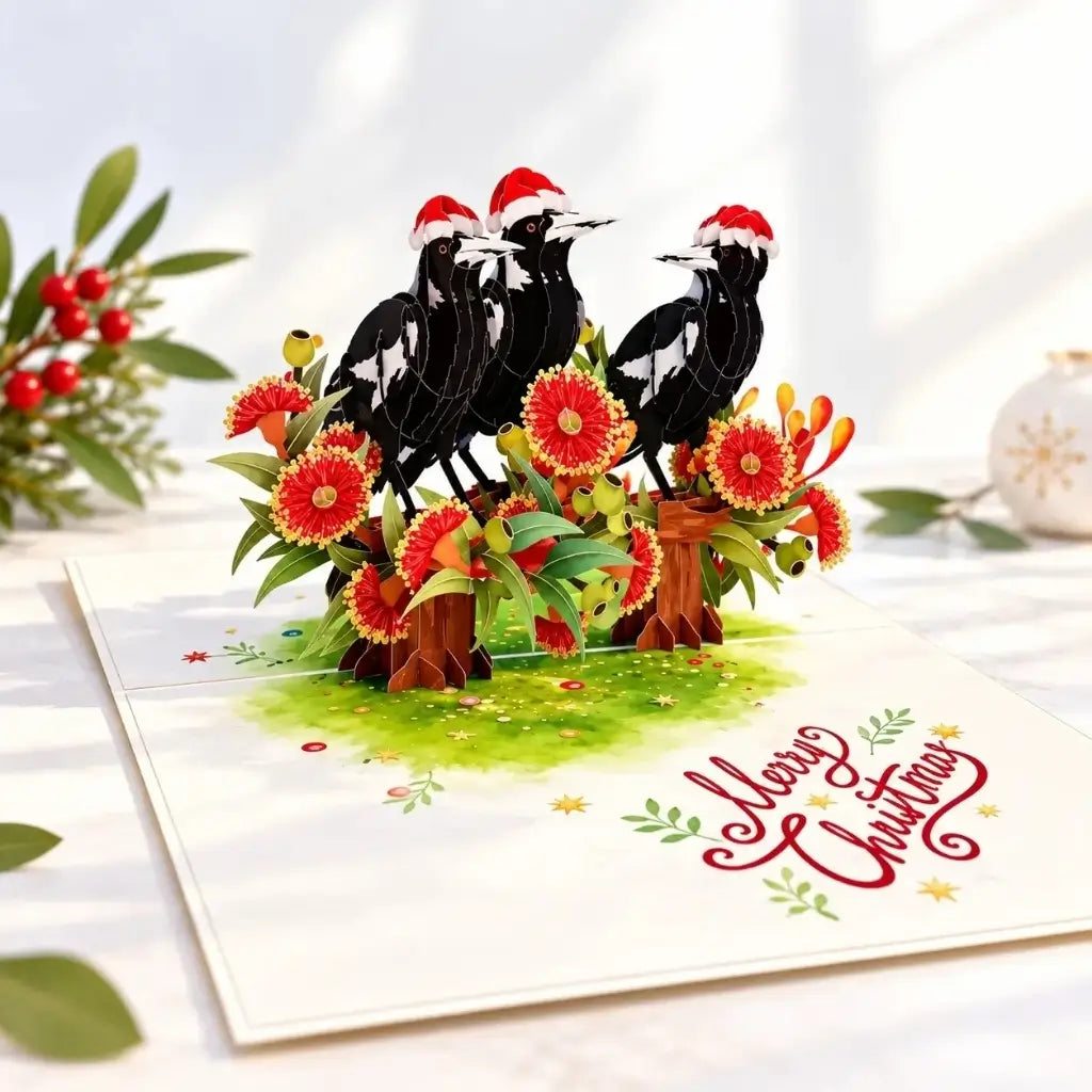 Magpie Christmas card surrounded by red gum blossoms and greenery
