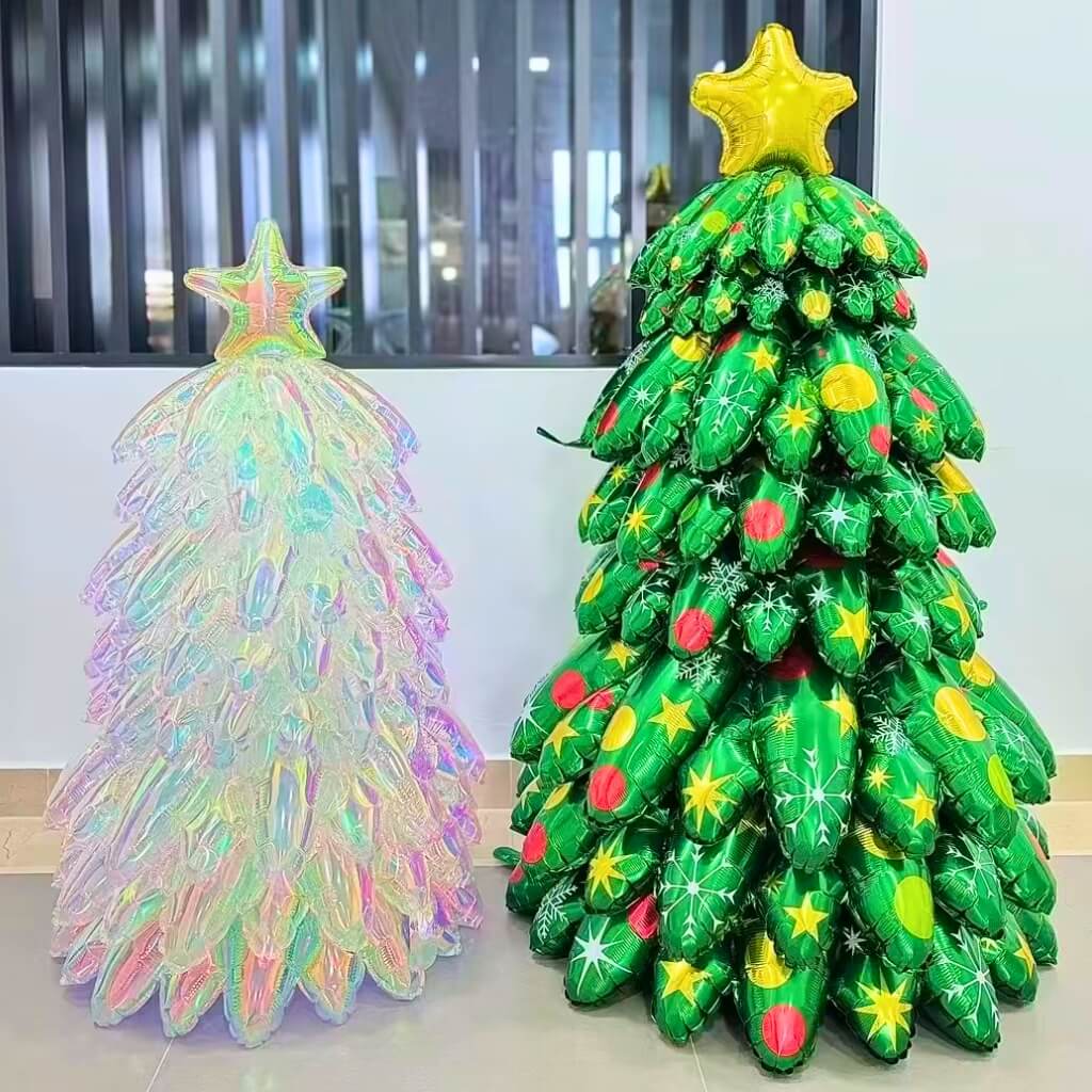 Inflatable green Christmas tree made of balloons with a gold star on top, next to a transparent inflatable tree.