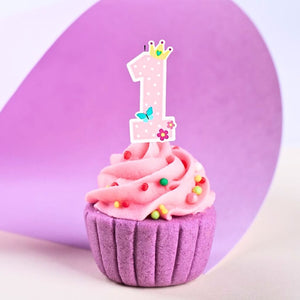 Girls pink and white number 1 birthday candle inserted on cupcake