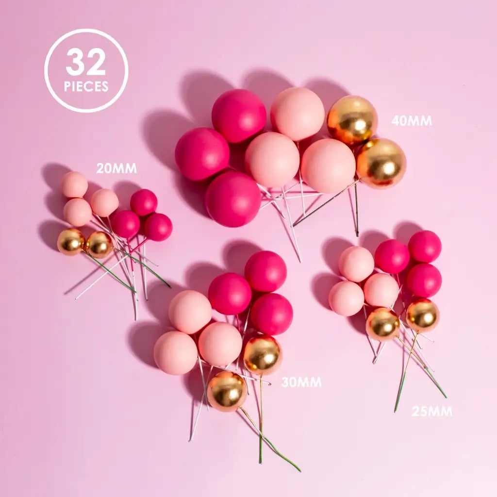 pink gold cake ball toppers on pastel cake