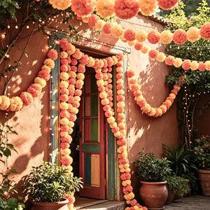 fluffy yellow and orange pom poms on a traditional Indian decorative garland