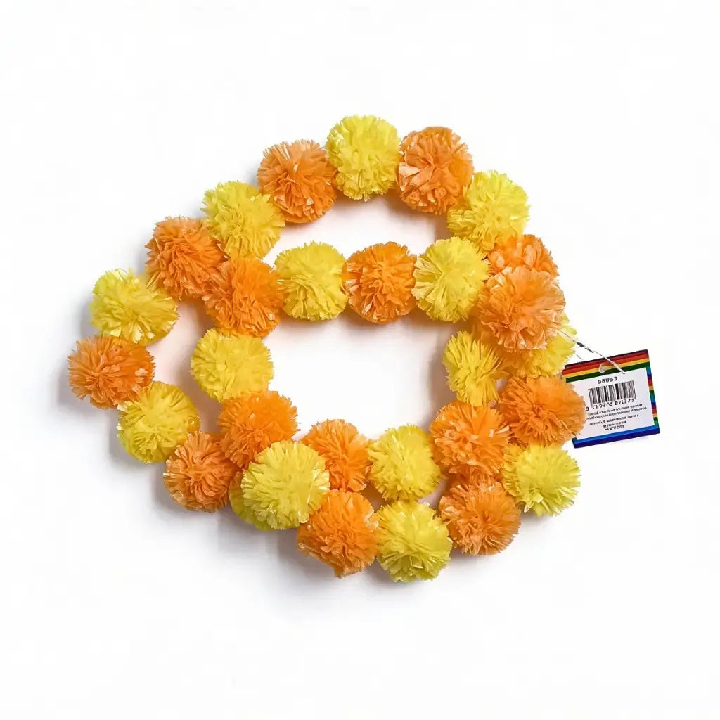 Yellow and orange Indian pom pom garland decorating a traditional haldi wedding ceremony backdrop