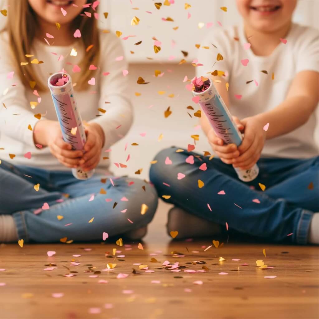 Gender reveal popper releasing pink and gold foil hearts