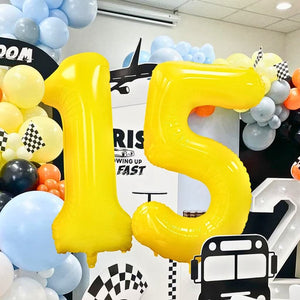 Yellow number 15 balloon with colorful balloons and checkered patterns in the background