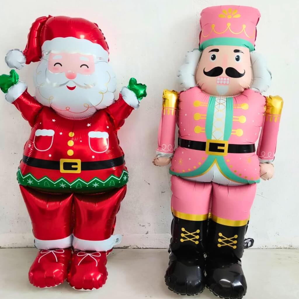 Inflatable Santa Claus and Nutcracker character against a white background