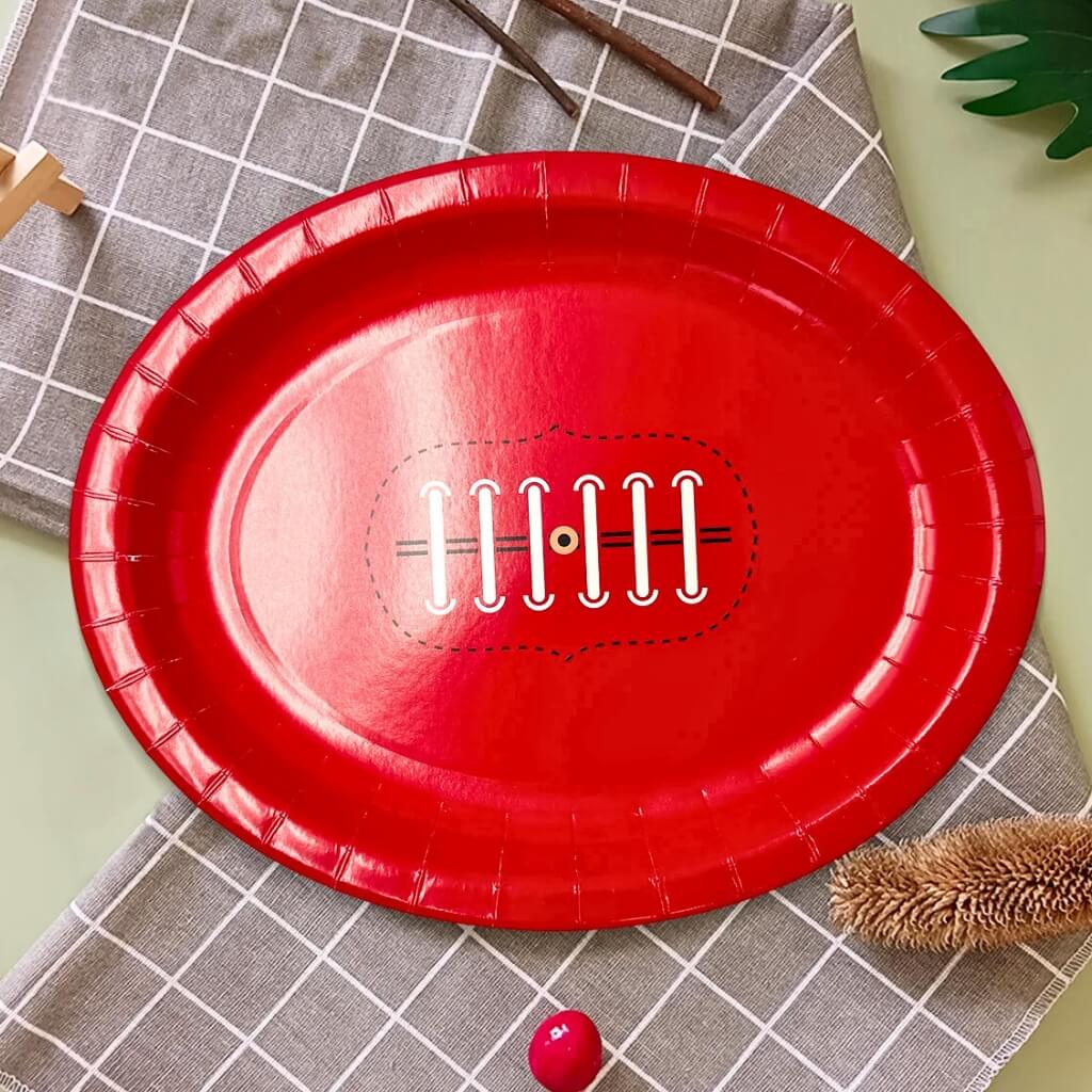Red paper plate with a football design on a white background