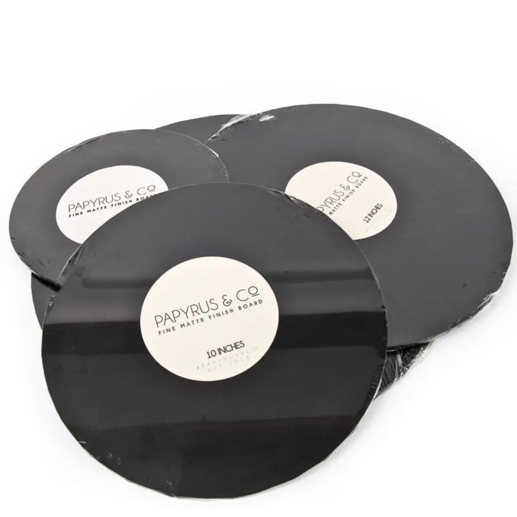 Minimalist white wedding cake presented on matte black round cake boards
