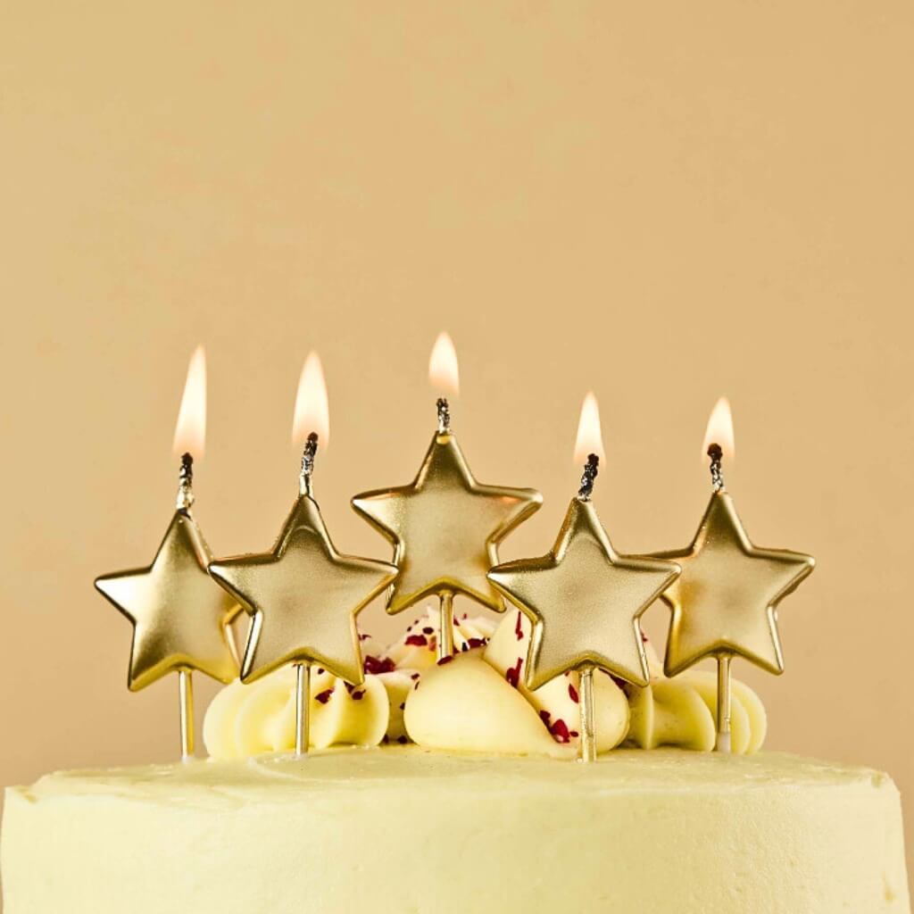 Gold metallic star cake candles on birthday cake