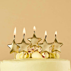 Gold metallic star cake candles on birthday cake