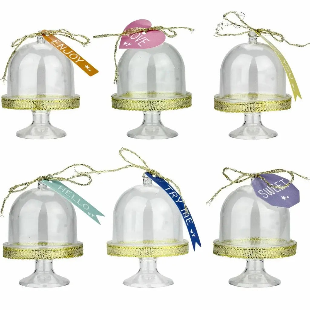 Decorated mini cake domes with gold ribbon and tag