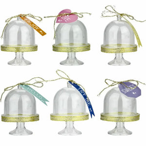 Decorated mini cake domes with gold ribbon and tag