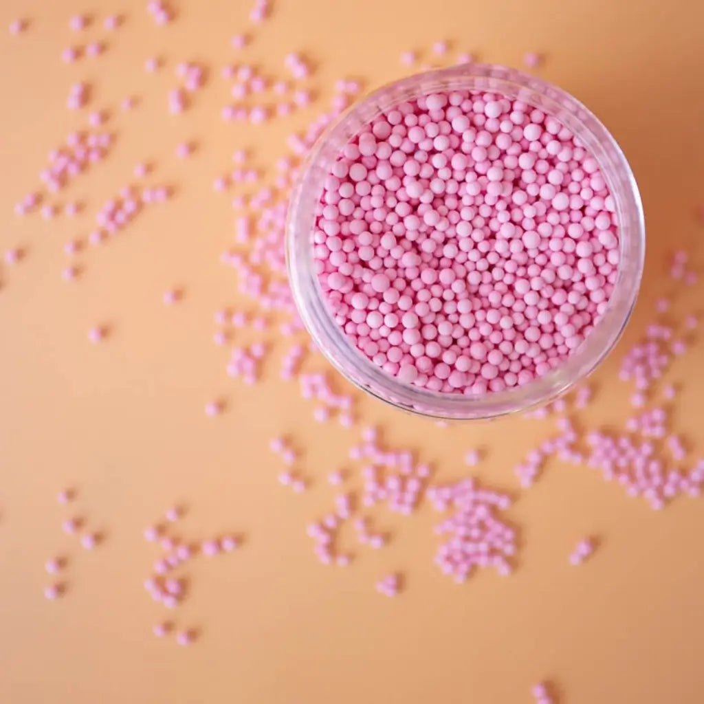 Pink edible sugar pearls in wide-mouth jar by Sprinks