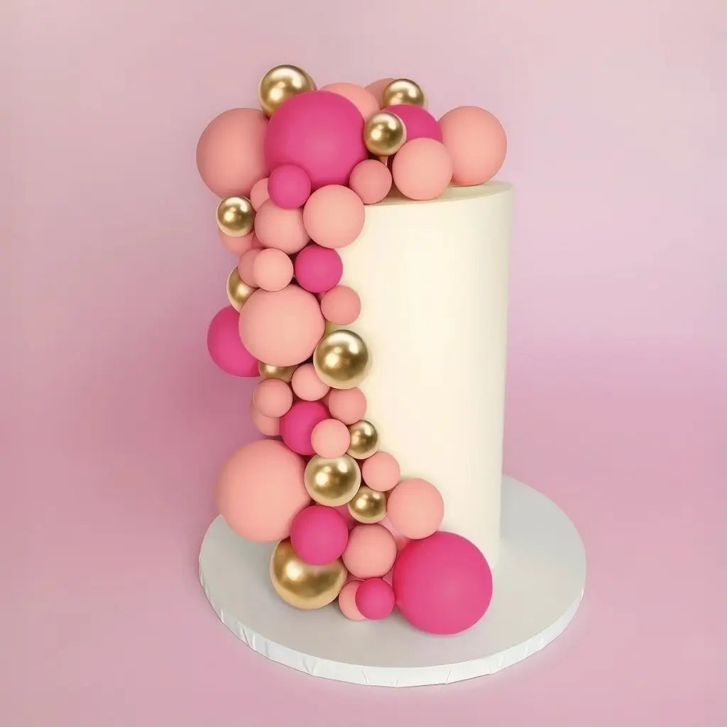 pink gold cake ball toppers on pastel cake