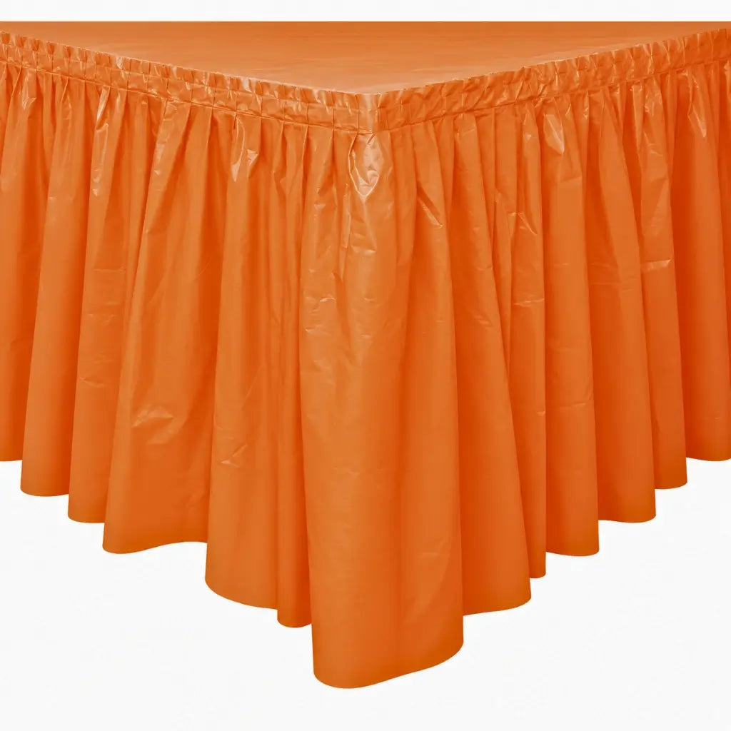 Pumpkin orange plastic party table skirt with gathered pleats measuring 73cm high and 4.3m long