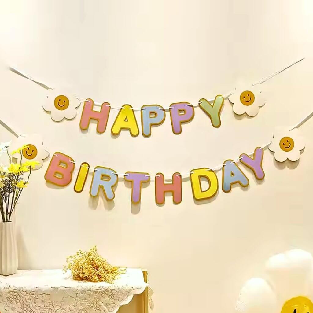 Rainbow Happy Birthday paper banner with four smiling daisy flowers