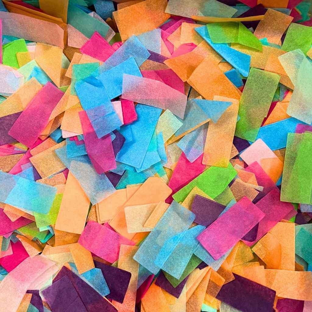 Colorful confetti pieces in various shades of pink, blue, green, orange, and purple.