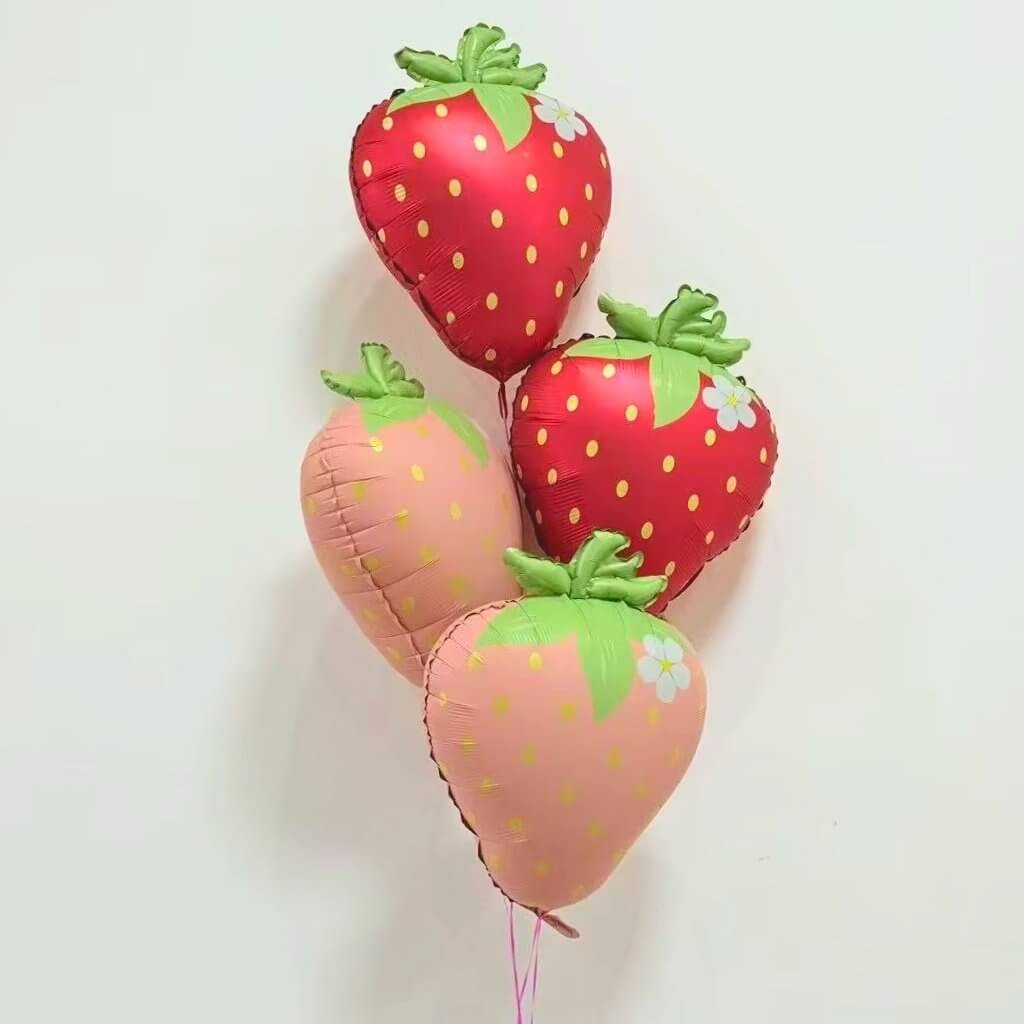 pastel pink Strawberry-shaped balloon with green leaves and a white flower on a white background