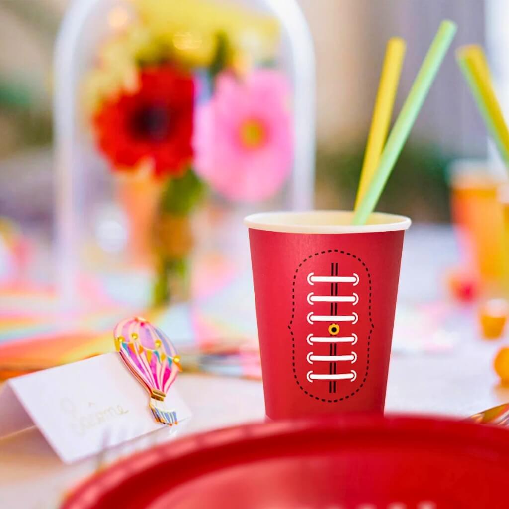Red paper cup with football design on a white background
