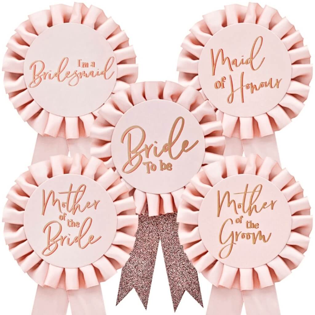 Set of pink ribbons with gold text for bridal party roles on a white background
