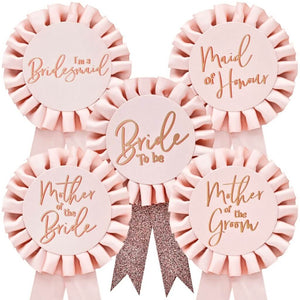Set of pink ribbons with gold text for bridal party roles on a white background